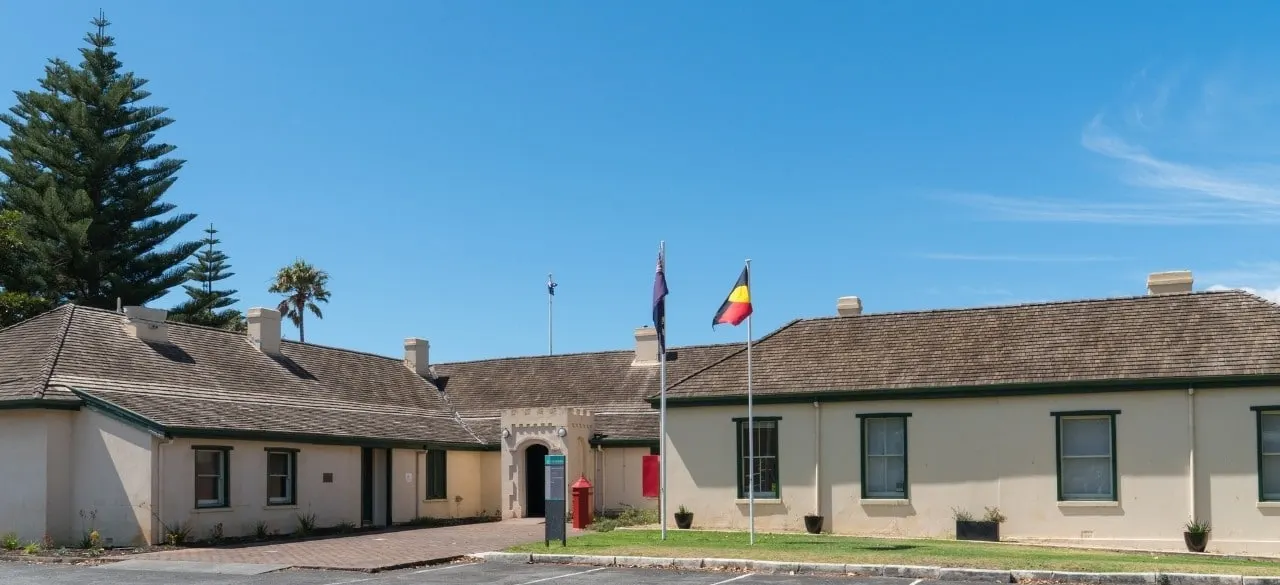 The long, single-storey heritage Residency Building in Albany, with cream walls and a shingled roof