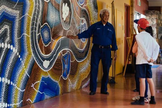 A guide showing visitors the gallery mural inside the Kodja Place in Kojonup