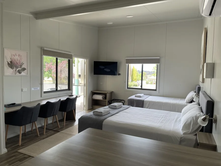 Work desk row and twin beds, set up for working travellers