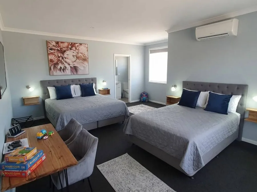 Family room with a queen bed, king single bed and board games on the table