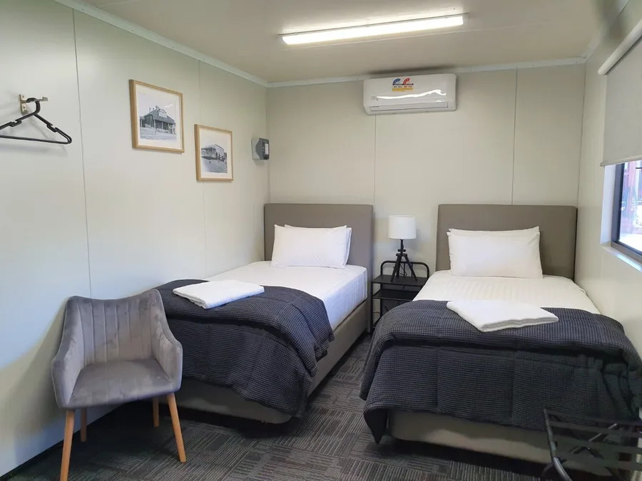 Twin room with two king single beds and heritage photographs on the wall